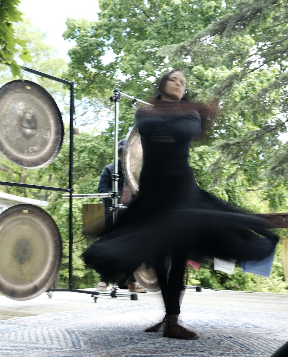 Fanny Peréz Gutiérrez whirls in front of the Wall of Gongs at Drone Day 2025 in Marlboro NY
